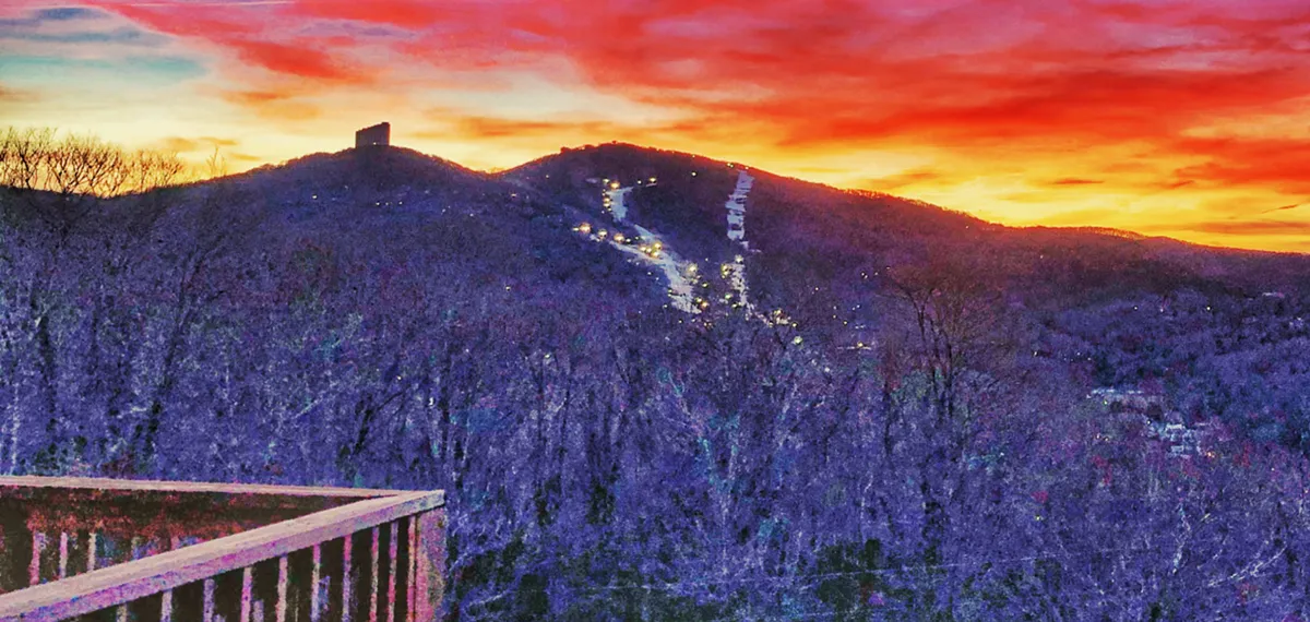 The image showcases the majestic mountains at sunset with ski slopes illuminated, creating a tranquil yet exciting winter ambiance. The scenery hints at evening adventures, from night skiing to relaxing under the stars after a day on the trails.